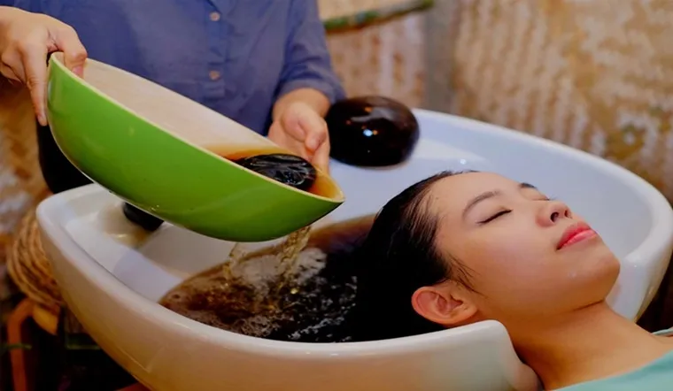 Khách hàng thư giãn trong quá trình ủ tóc bằng dưỡng chất tự nhiên tại NguyenBeauty